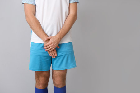 Male football player on gray backgroundの写真素材