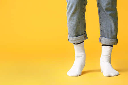 Male legs in socks and jeans on color backgroundの写真素材
