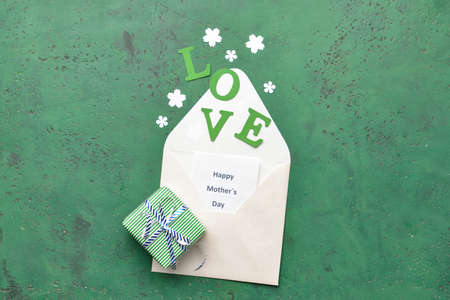 Beautiful greeting card and gift for Mother's Day on color background