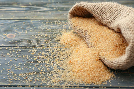Sack with sweet sugar on wooden backgroundの写真素材