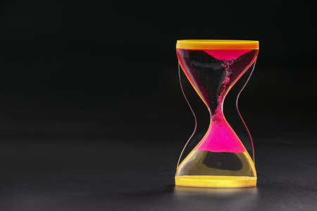 Hourglass on dark background. Time management conceptの写真素材