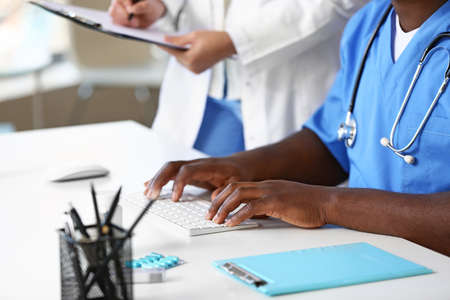 African-American doctor working on PC in clinic
