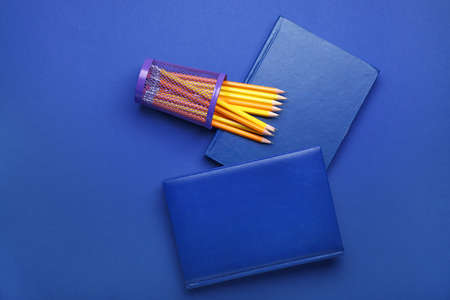 Ordinary pencils and notebooks on color backgroundの写真素材