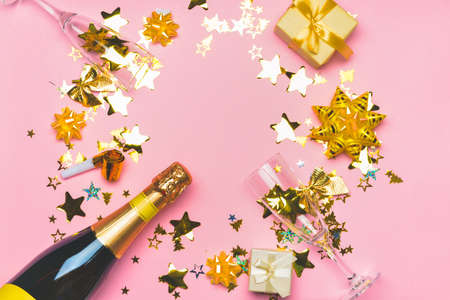 Glasses and bottle of tasty champagne with party decor and gifts on color background