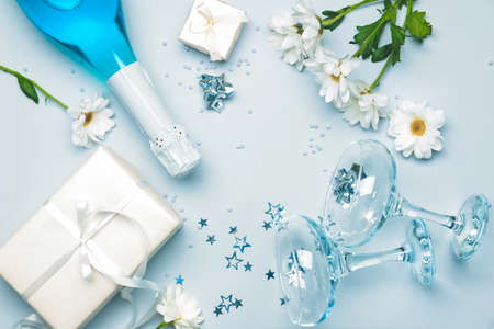 Glasses and bottle of tasty champagne with gifts on white backgroundの写真素材