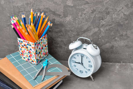 Set of school supplies and clock on tableの写真素材