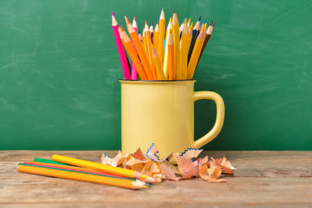 Many pencils on table near blackboardの写真素材