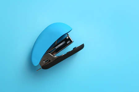 Office stapler on color background