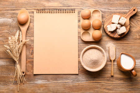 Cook book with products on wooden backgroundの写真素材