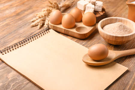 Cook book with products on wooden backgroundの写真素材