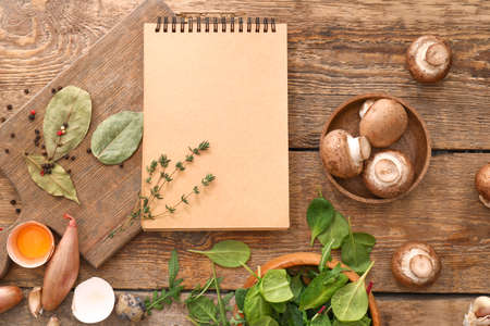 Cook book with products on wooden background