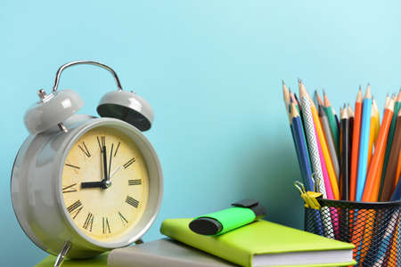 Set of school supplies and clock on table. Time to study