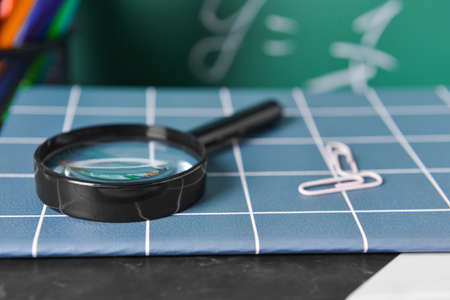 Magnifier, notebook and paper clips on table, closeupの写真素材