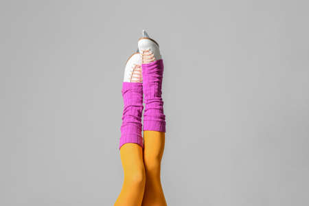 Young woman in ice skate shoes on gray backgroundの写真素材
