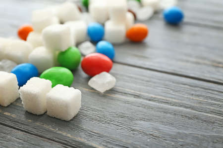 Sweet sugar and candies on wooden backgroundの写真素材