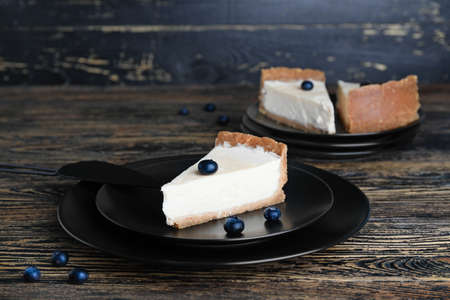 Plate with piece of sweet tasty cheesecake on table