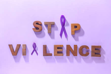 Violet ribbons and text DOMESTIC VIOLENCE on color background
