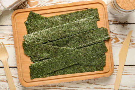 Plate with tasty seaweed sheets on table