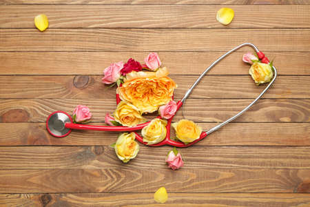 Stethoscope with flowers on wooden backgroundの写真素材