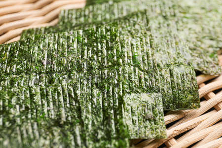 Tasty seaweed sheets on bamboo mat, closeupの写真素材