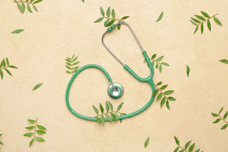 Stethoscope with leaves on color backgroundの写真素材