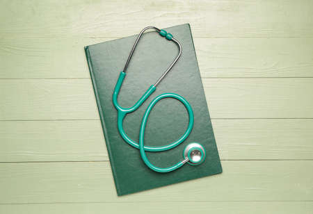 Stethoscope with notebook on color wooden backgroundの写真素材