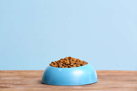 Bowl with dry pet food on table