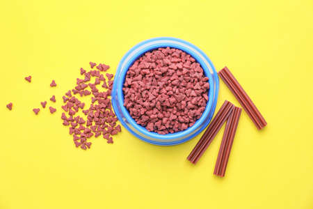 Bowl with dry pet food on color backgroundの写真素材