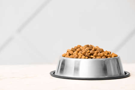 Bowl with dry pet food on tableの写真素材