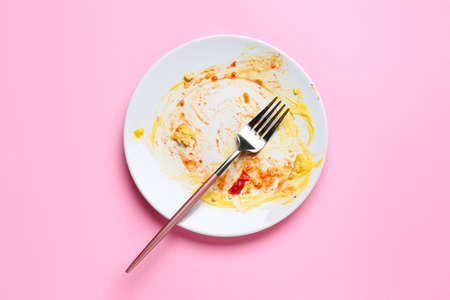 Dirty empty plate with fork on color backgroundの素材 [FY310166067319]