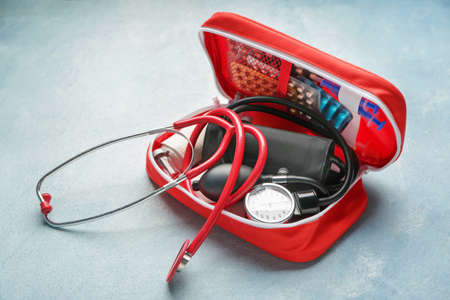 First aid kit on color background