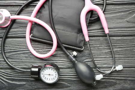 Stethoscope with sphygmomanometer on dark wooden backgroundの写真素材