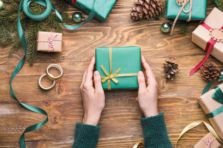 Woman with beautiful Christmas gift at table