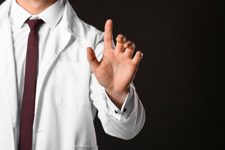 Male doctor using virtual screen on dark backgroundの写真素材