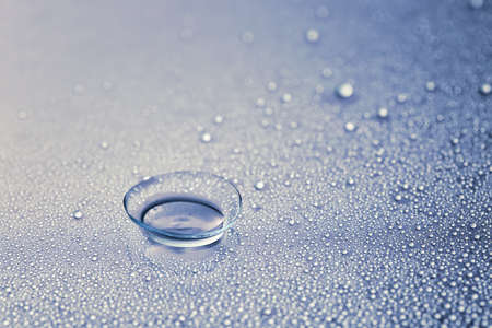 Contact lens and water drops on color backgroundの写真素材