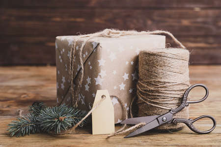 Beautiful gift for Christmas with supplies on wooden backgroundの写真素材