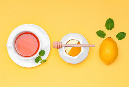 Tasty honey with lemon and cup of tea on color background