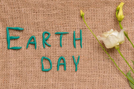 Text EARTH DAY and flowers on sackclothの写真素材