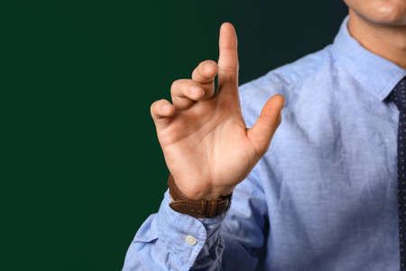 Young businessman using virtual screen on dark backgroundの写真素材