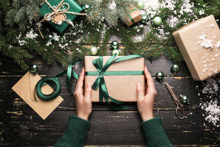 Woman with beautiful Christmas gift at tableの写真素材