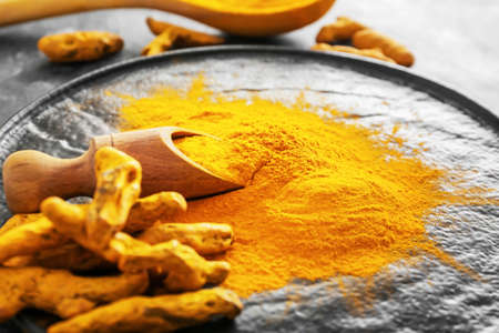 Scoop with aromatic turmeric on plate, closeupの写真素材