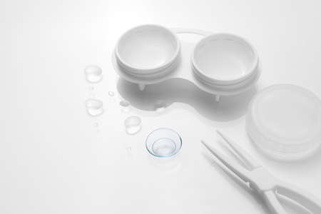 Contact lenses with case and tweezers on white backgroundの写真素材