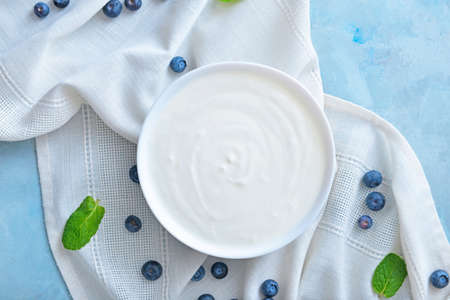 Bowl with tasty yogurt and berries on color backgroundの写真素材