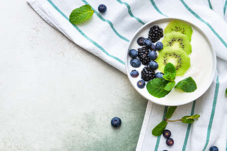 Bowl with tasty yogurt and fruits on light backgroundの写真素材