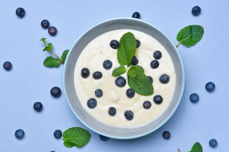 Bowl with tasty yogurt and berries on color backgroundの写真素材