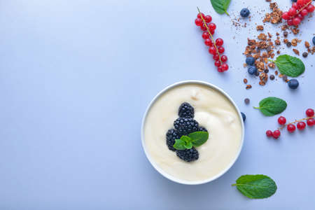 Bowl with tasty yogurt and berries on color backgroundの写真素材