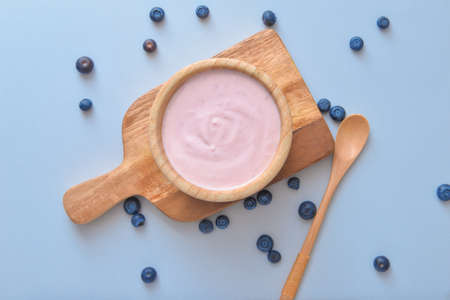 Bowl with tasty yogurt and berries on color backgroundの写真素材
