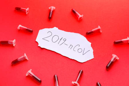 Test tubes with blood sample and text 2019-nCoV on color backgroundの写真素材