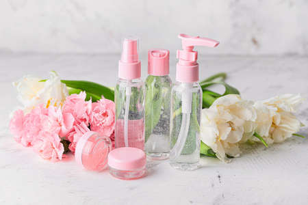 Different cosmetic products with flowers on white backgroundの写真素材