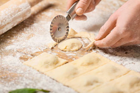 Woman preparing tasty ravioli on tableの写真素材